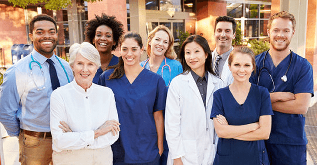 Group of doctors posing for a group photo smiling at the camera.