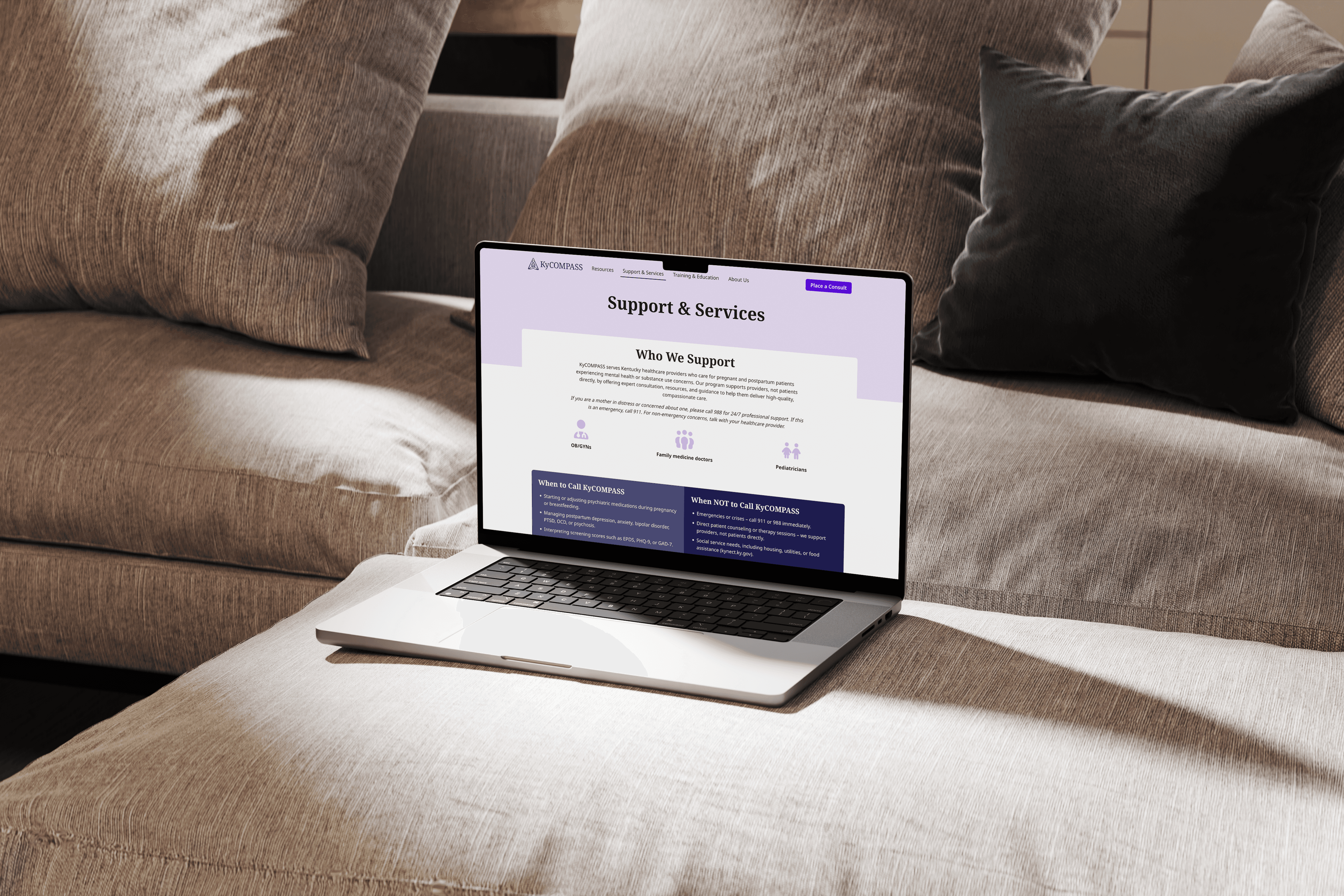 mockup of a laptop on a couch open to the KyCompass website